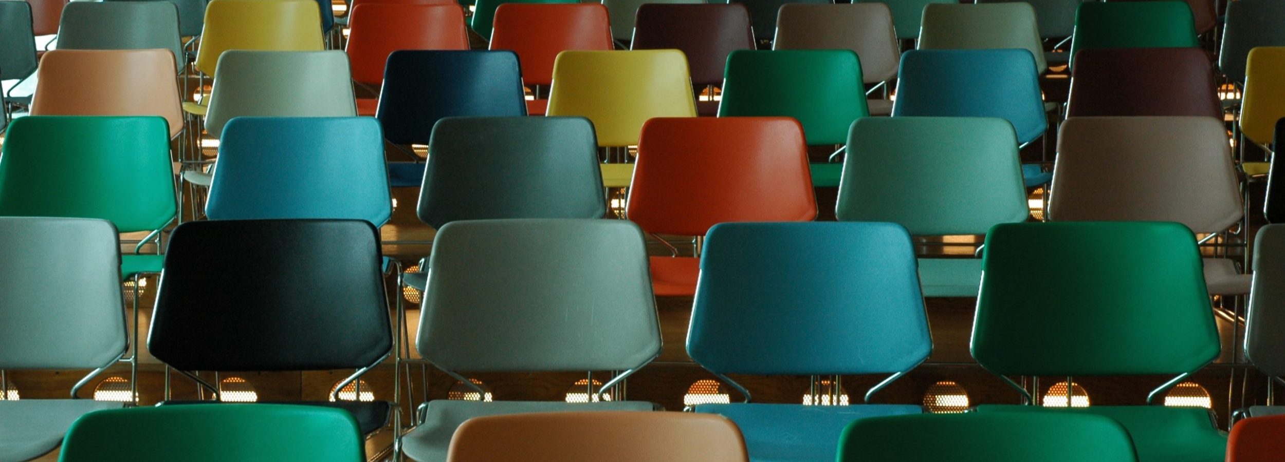 A room full of multi-colored chairs arranged theater-style.