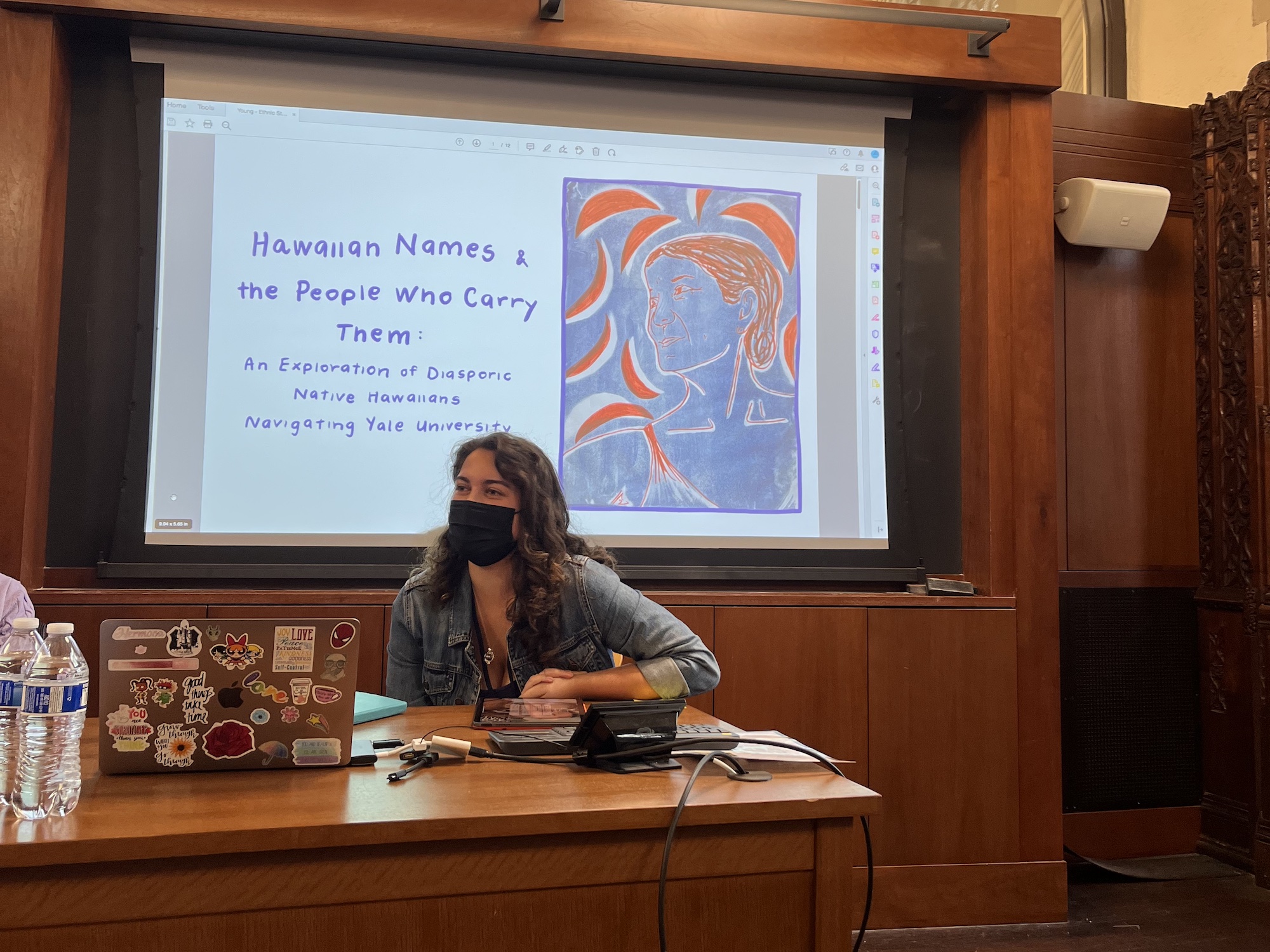 A student in front of a slide that reads "Hawaiian Names and the People Who Carry Them" at the 2023 Ethnic Studies Symposium.